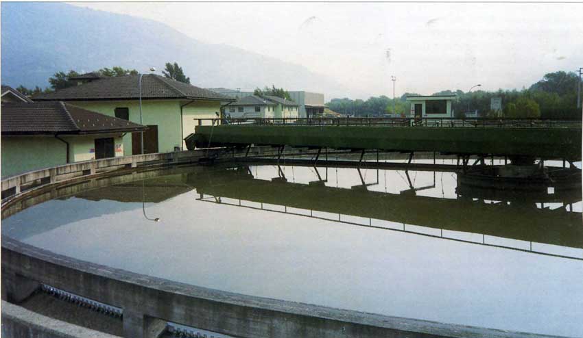 Vasca di sedimentazione primaria concarroponte raschiafanghi. Il fondo in leggera pendenza del sedimentatore consente la raccolta del fango al centro della vasca; l'uscita del liquame avviene per sfioro della lama profilata a piccoli stramazzi rettangolari successivi installati lungo la circonferenza del chiarificatore.Vasca di sedimentazione primaria concarroponte raschiafanghi. Il fondo in leggera pendenza del sedimentatore consente la raccolta del fango al centro della vasca; l'uscita del liquame avviene per sfioro della lama profilata a piccoli stramazzi rettangolari successivi installati lungo la circonferenza del chiarificatore.