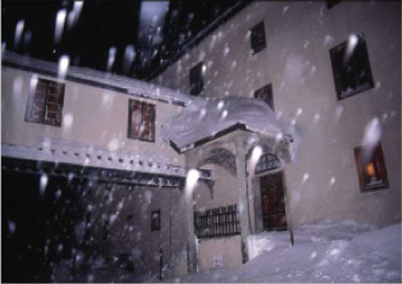 Una visione notturna dell'Ospizio sotto una fitta nevicata.