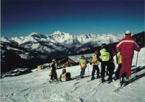 Un maestro di sci e i suoi giovani allievi, sulle piste di Pila.