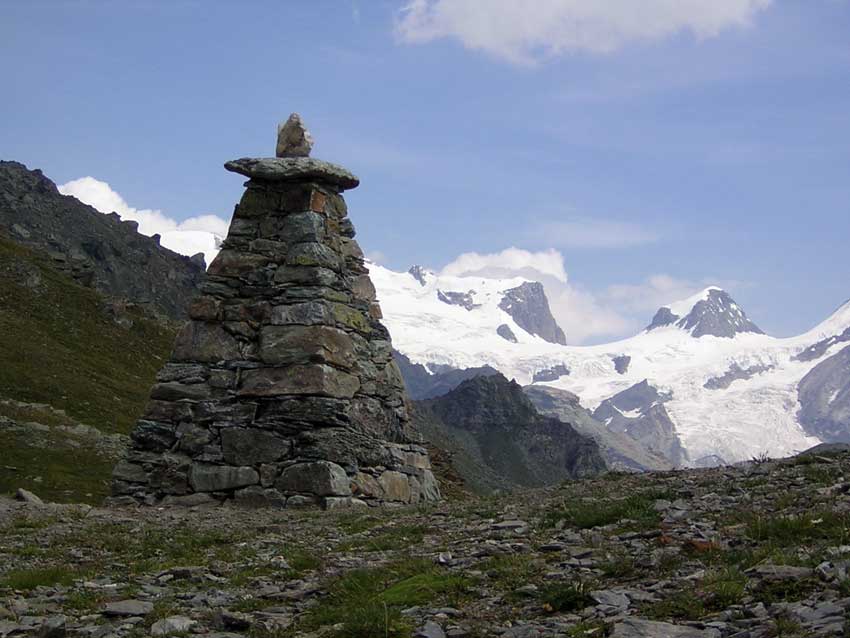 Una piramide segnaletica con lo sfondo di Roccia Nera e Polluce.