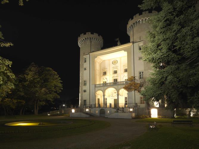 Vue nocturne de la partie du parc devant l'entrée et la façade principale du château