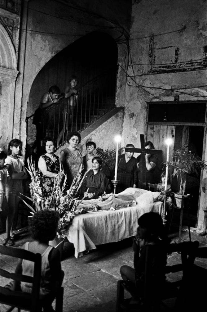 Letizia Battaglia |  La famiglia veglia il padre scomparso nell'androne della casa povera. Palermo, 1986 © Archivio Letizia Battaglia